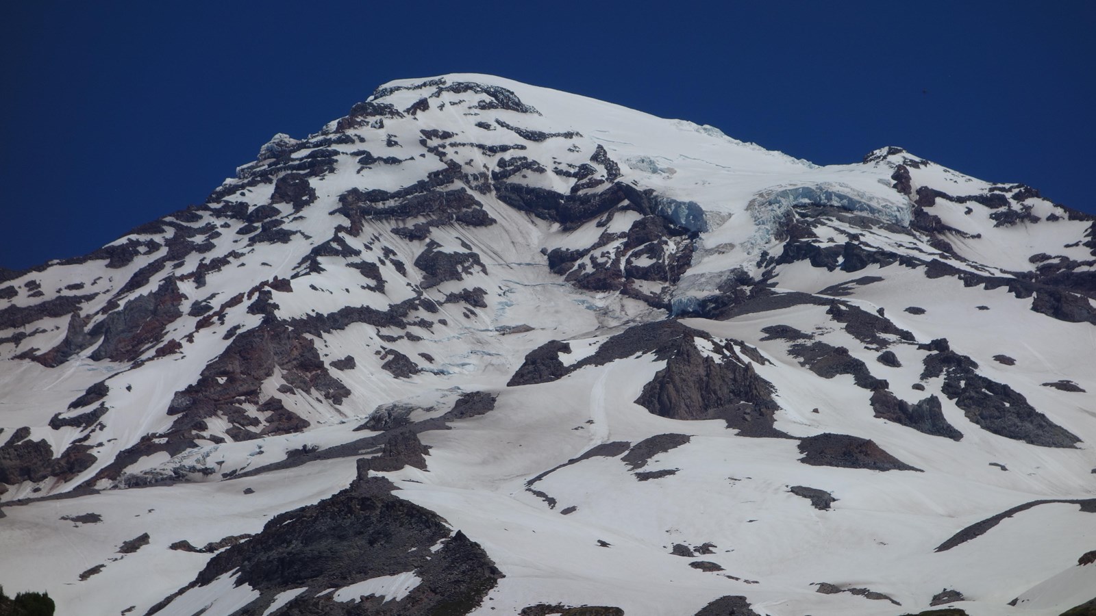 Long and narrow glacier on rocky glaciated mountain