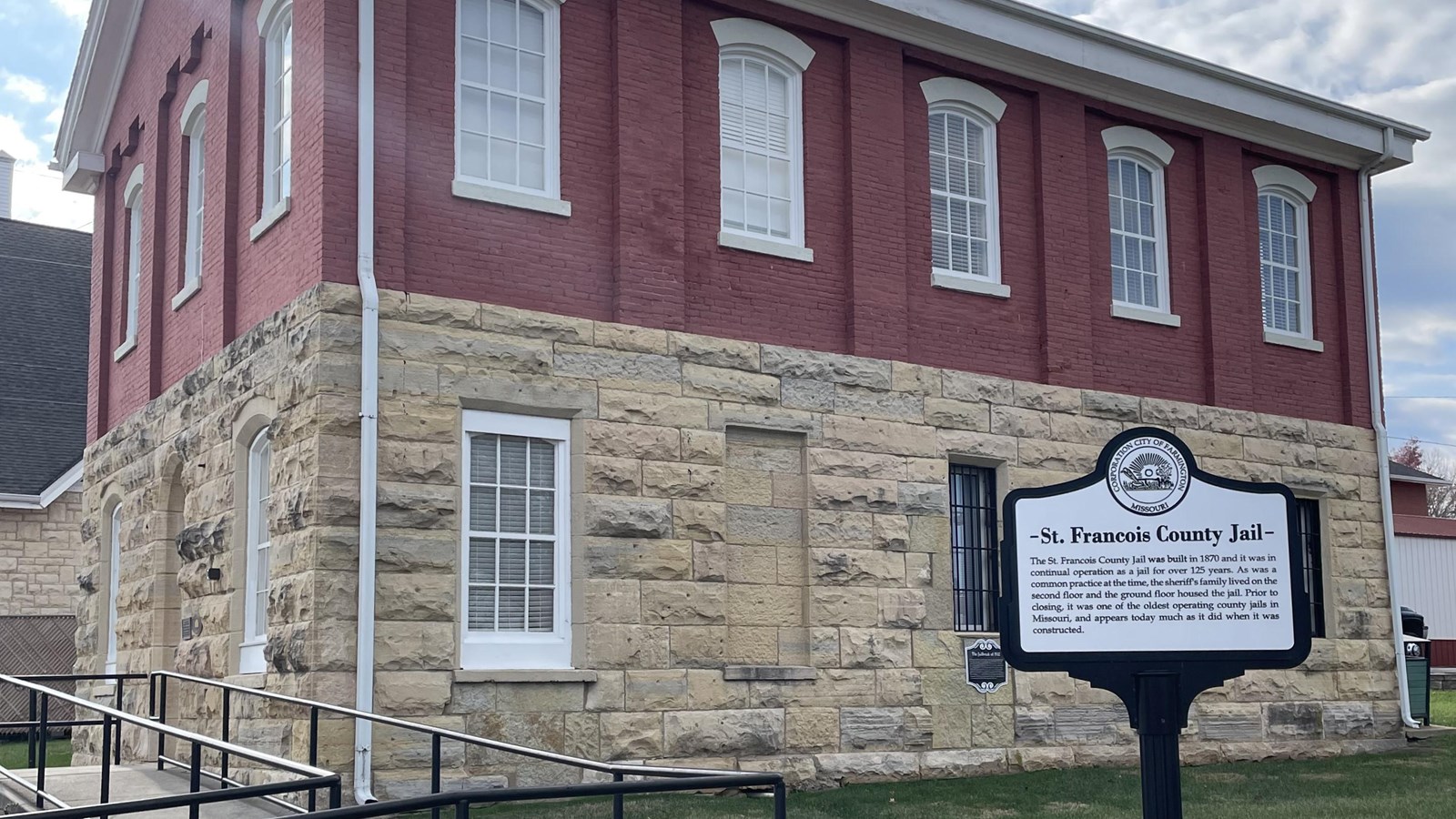 A large, stone, and brick building with a small sign.