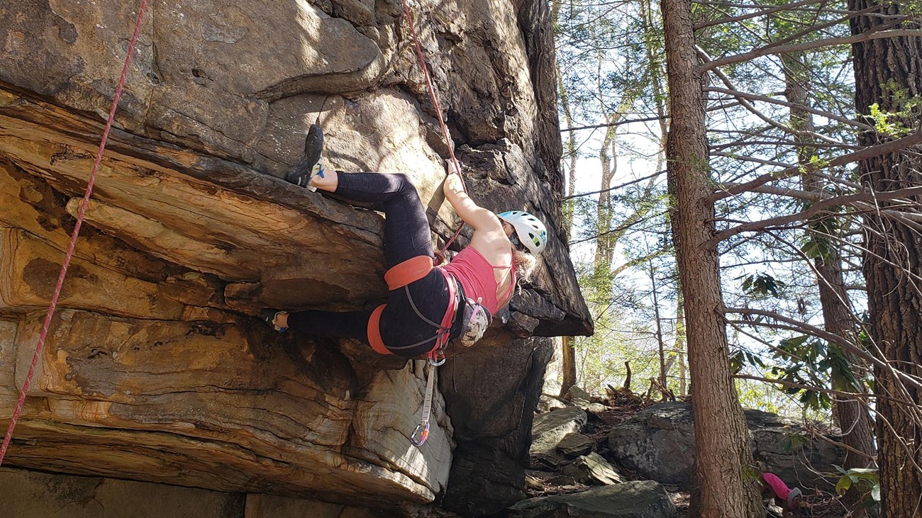 rock climber maneuvering around a small overhang