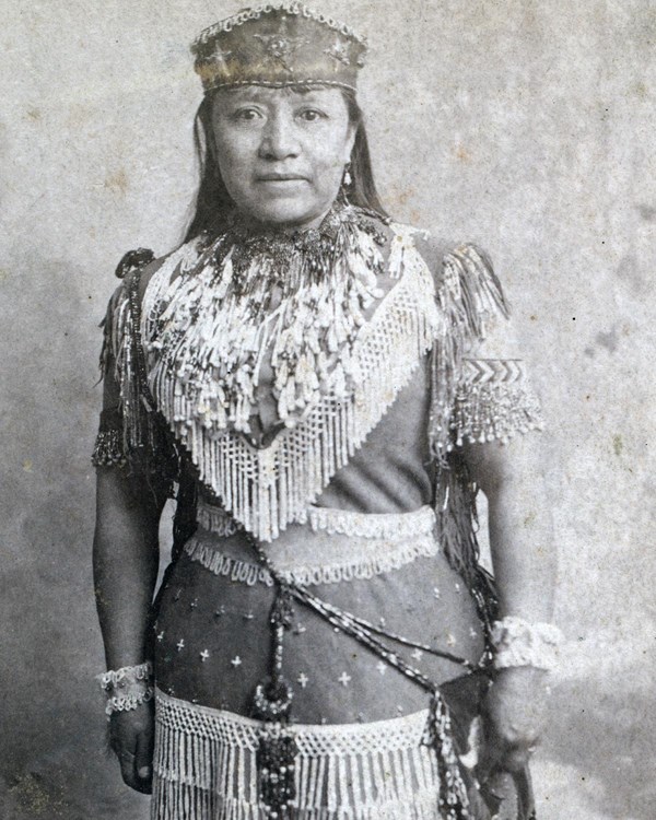 Full length portrait of Native American woman in non-traditional "Indian Princess" beaded costume