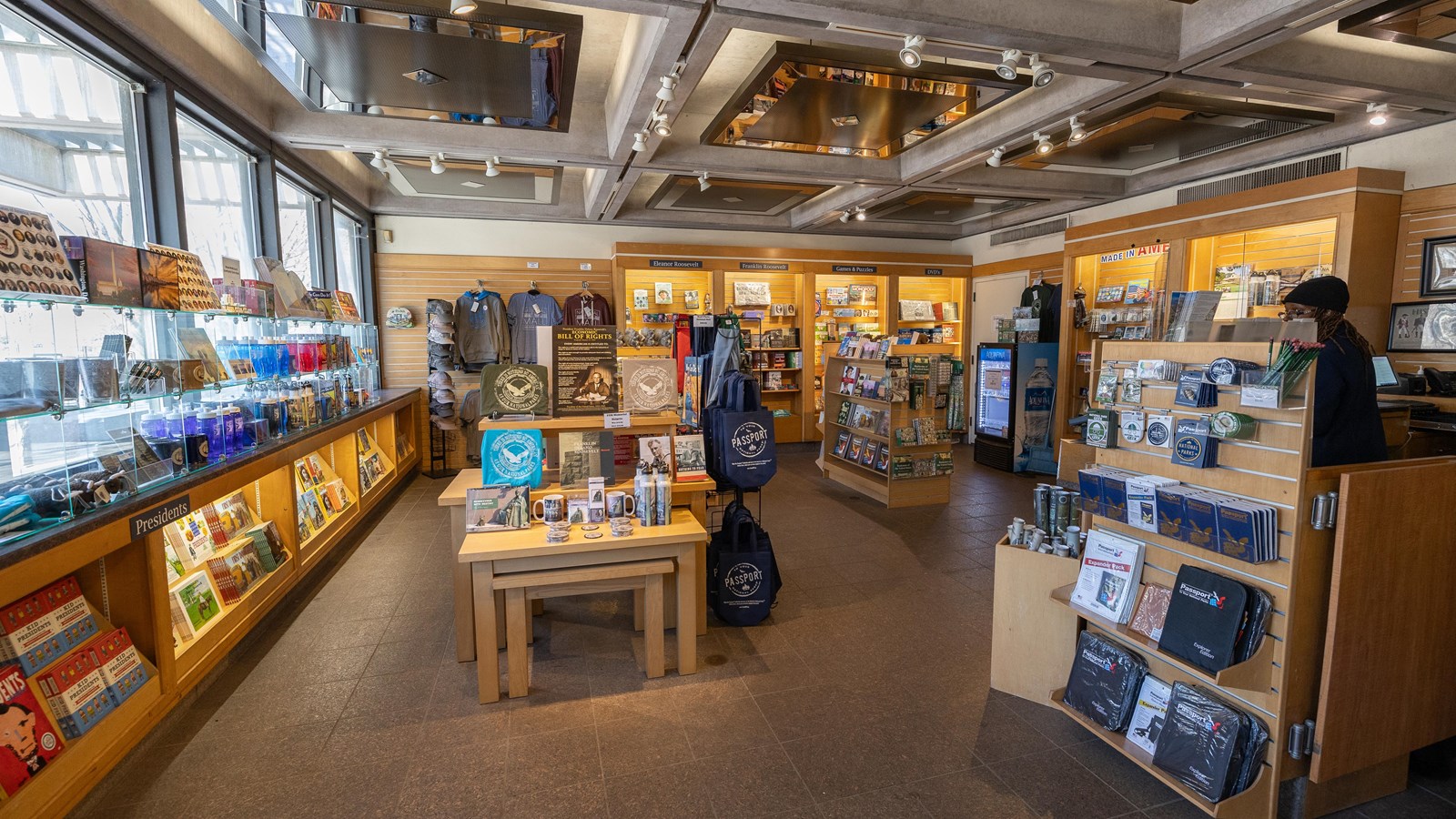 A bookstore with shelves of various items for sale and an information desk to the right.