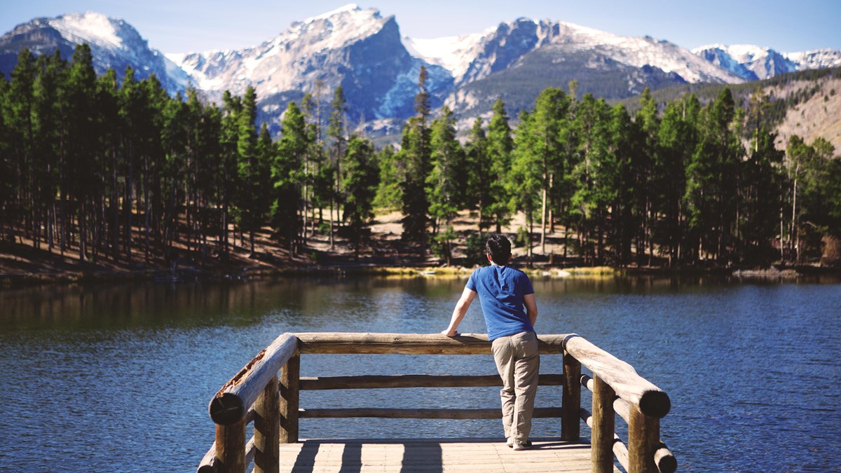a man looks out over the dock over a lake