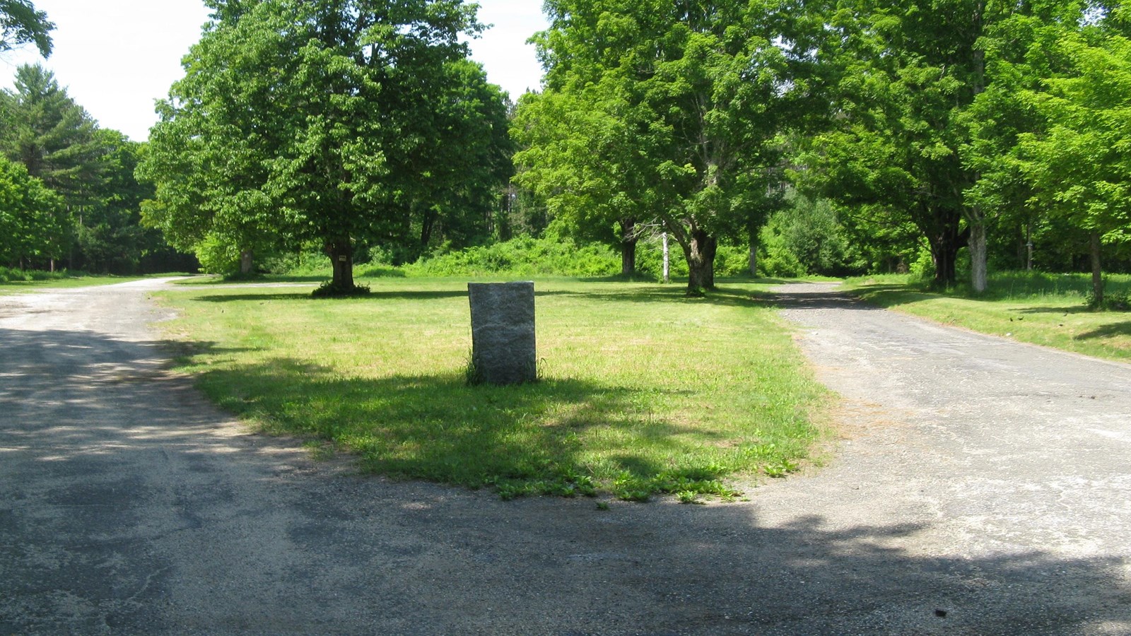 Photo of grassy area with marker denoting site of former town. 