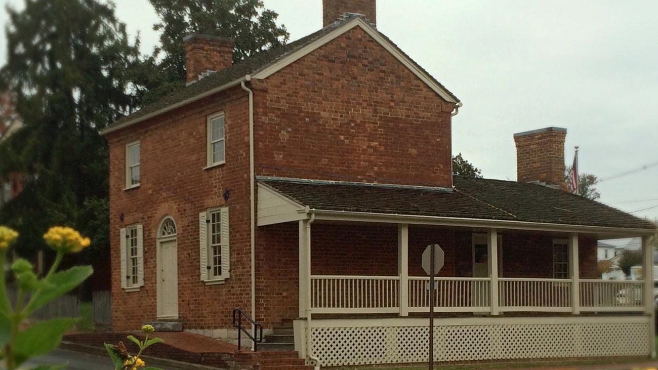 View of Early Home with flowers