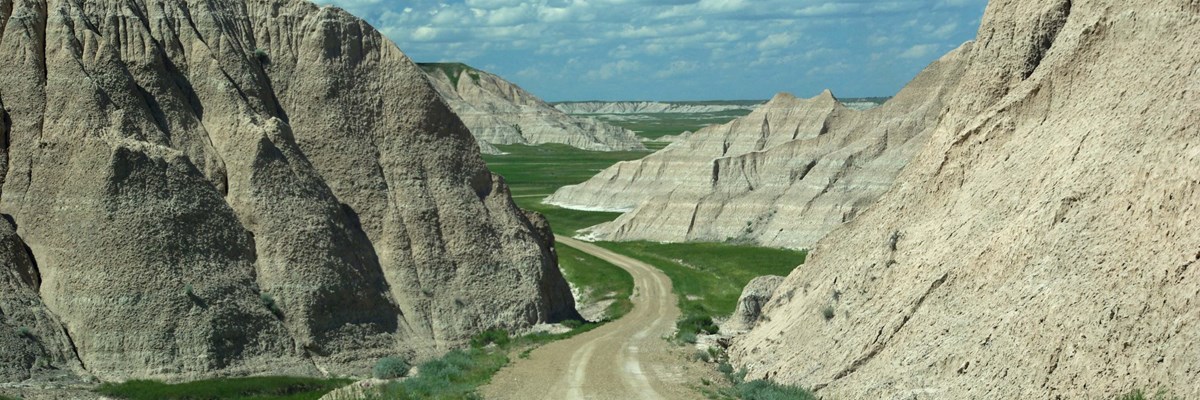 a dirt road meanders through badlands buttes