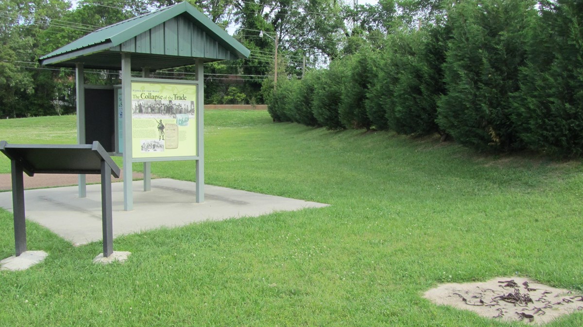 Free standing exhibits and wayside panels are located on the grassy lawn of the site of the market.