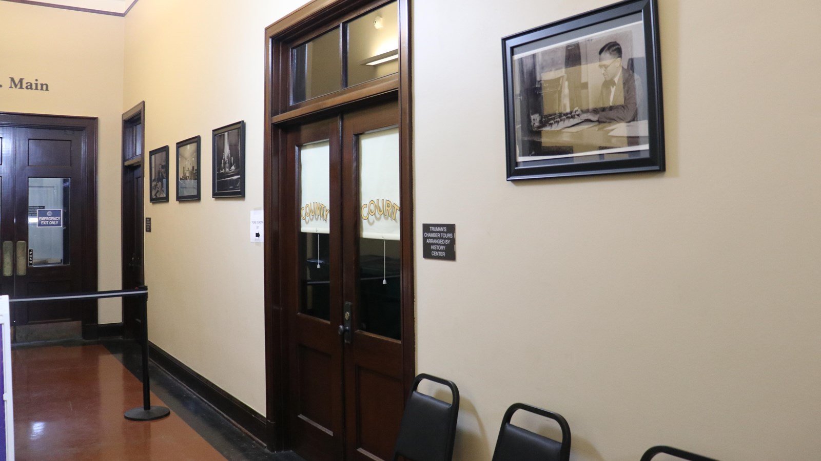 Two doors and photographs of Harry S Truman hang on the wall of the entrance to his office.