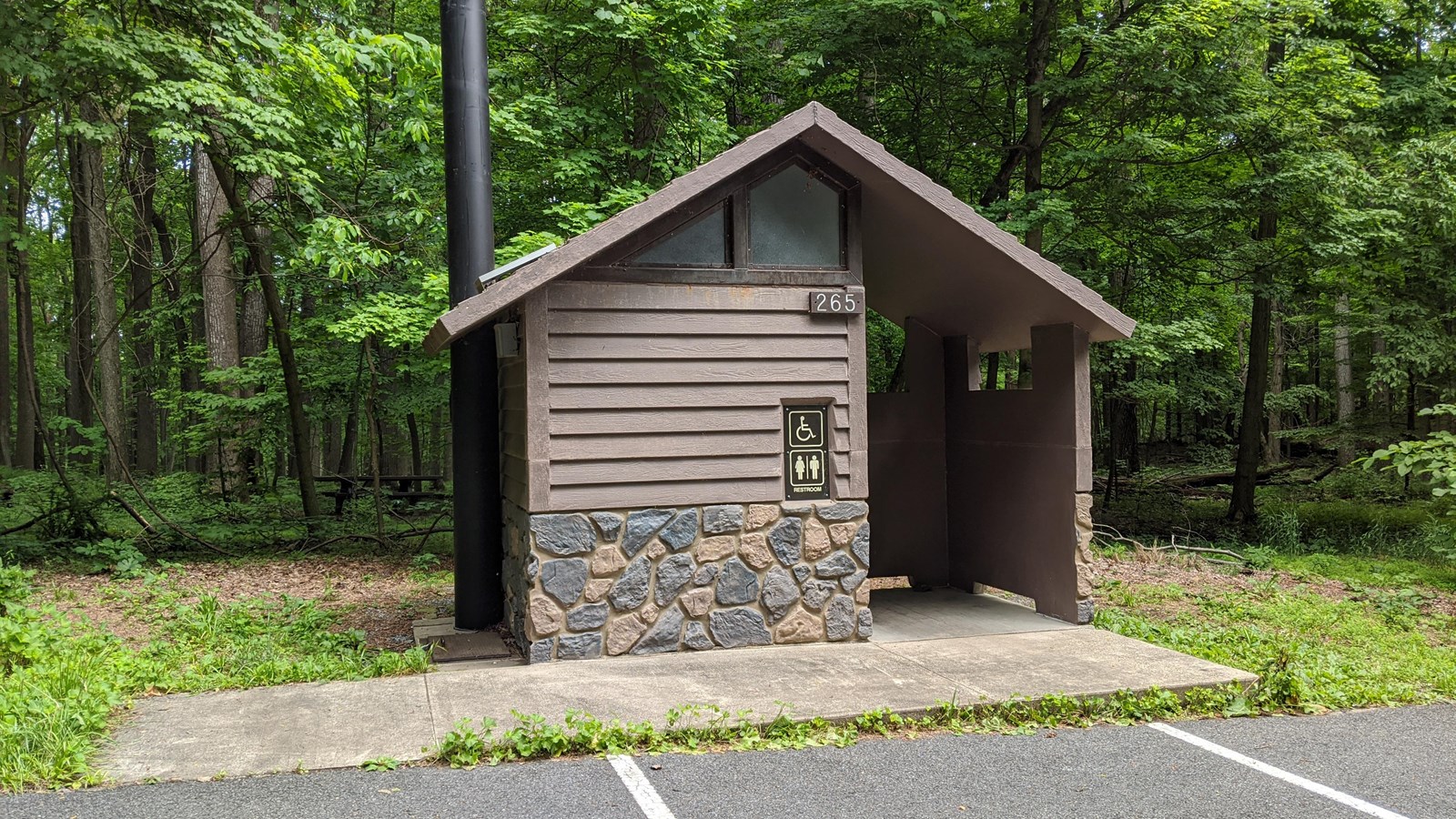 Wooden Structure with concrete ramp and sidewalk. The structure is located directy next to several p