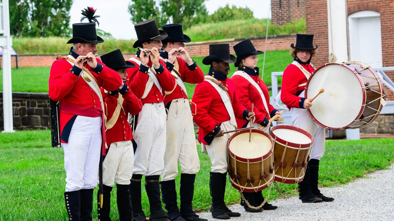 Living history members performing fifes and drums inside star fort.