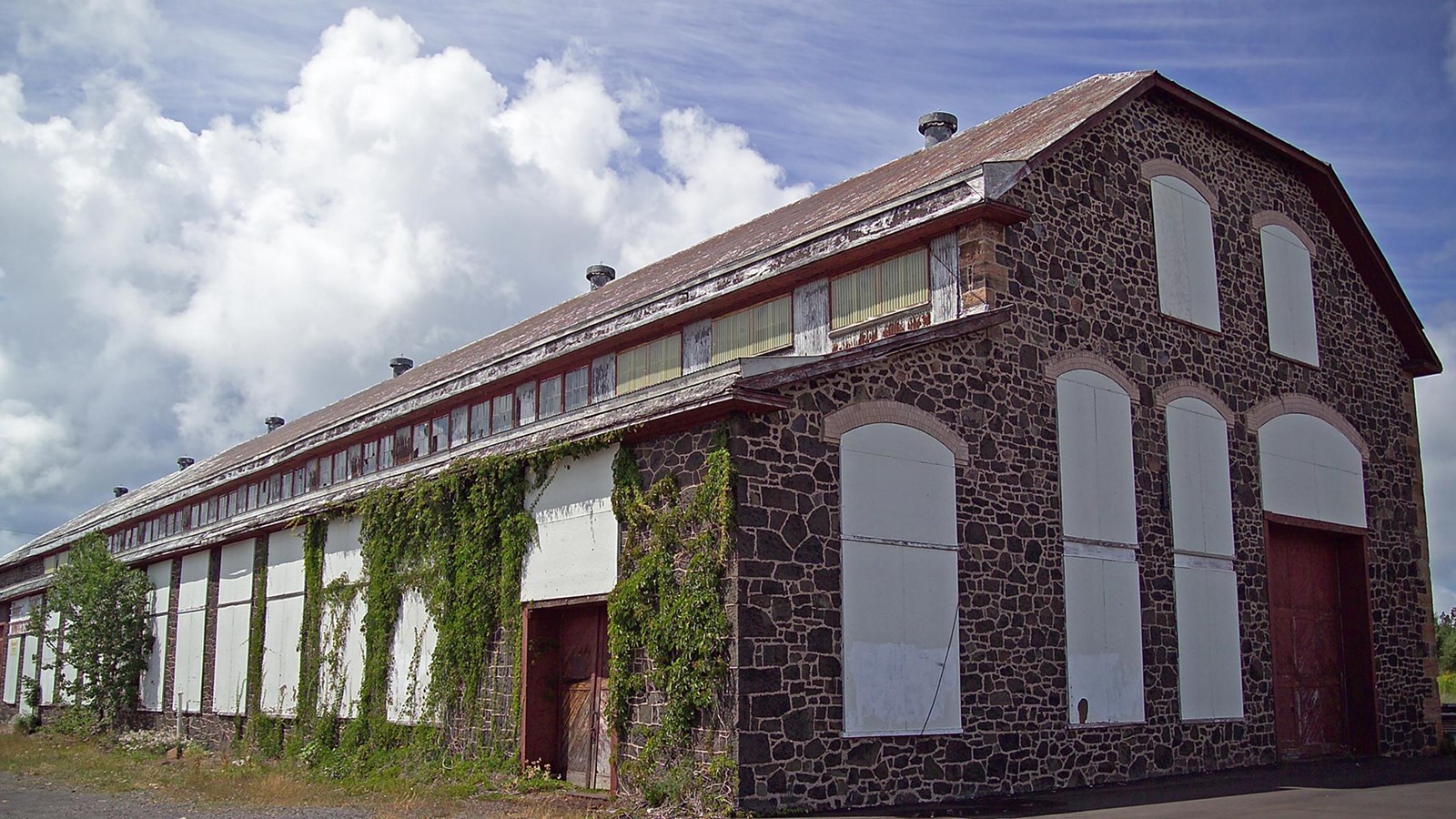 Summer scene of two-story poor-rock and brick building