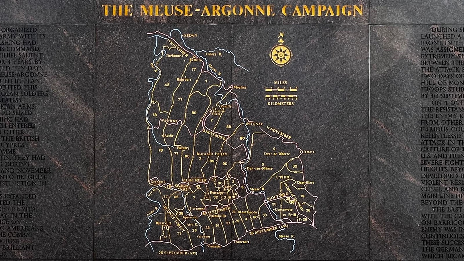 Tall dark colored wall with map outlined in gold with text