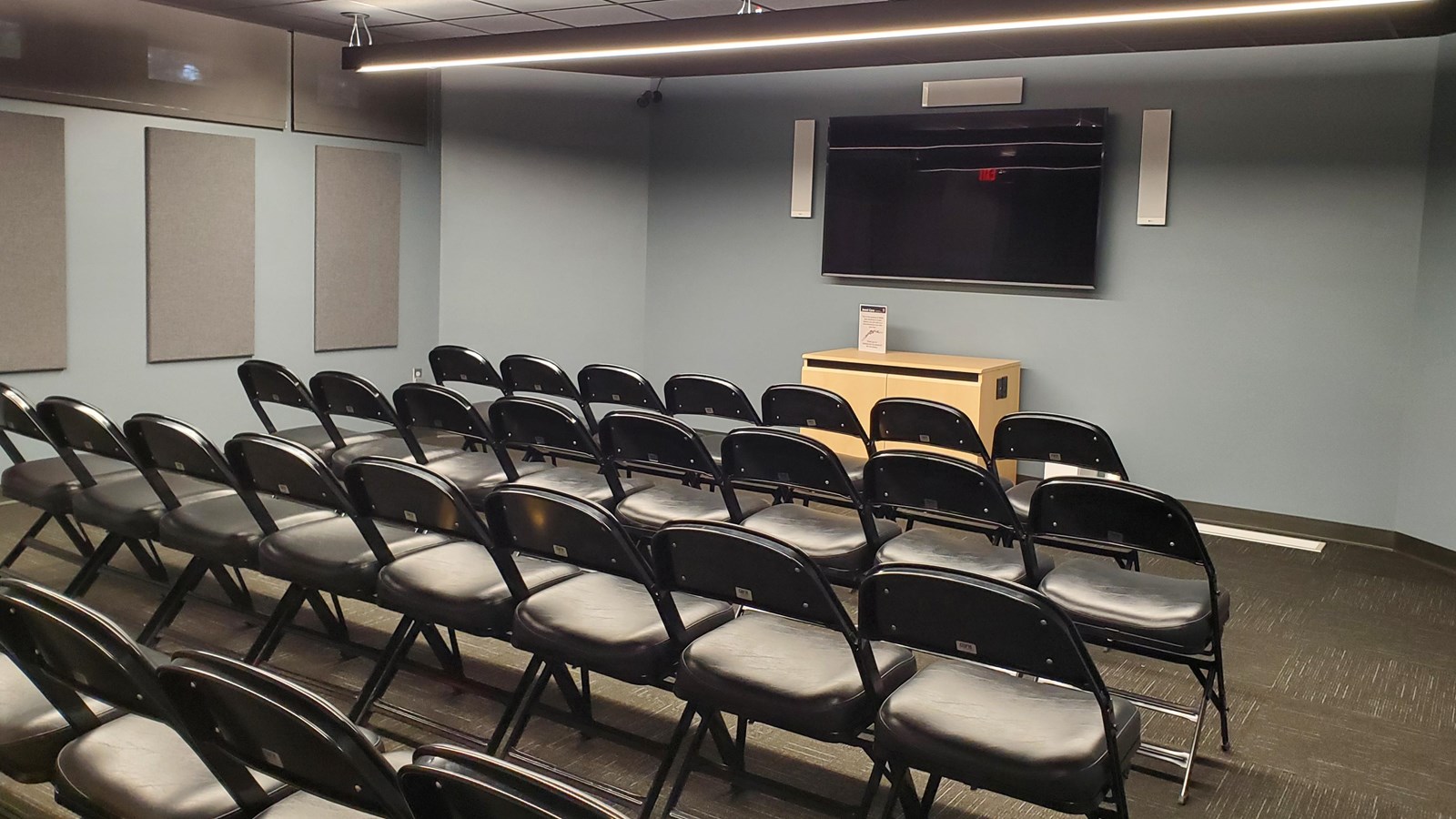 Chairs in front of a tv in grey room