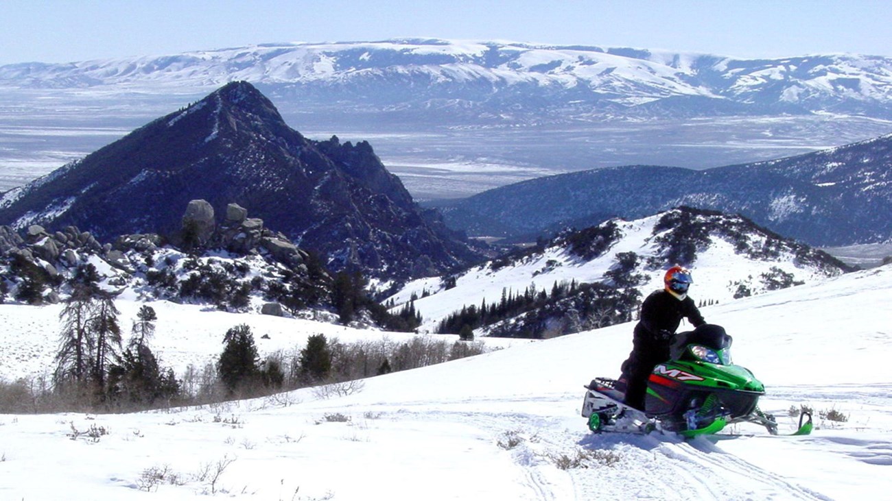 Person riding a snowmobile in the City of Rocks.