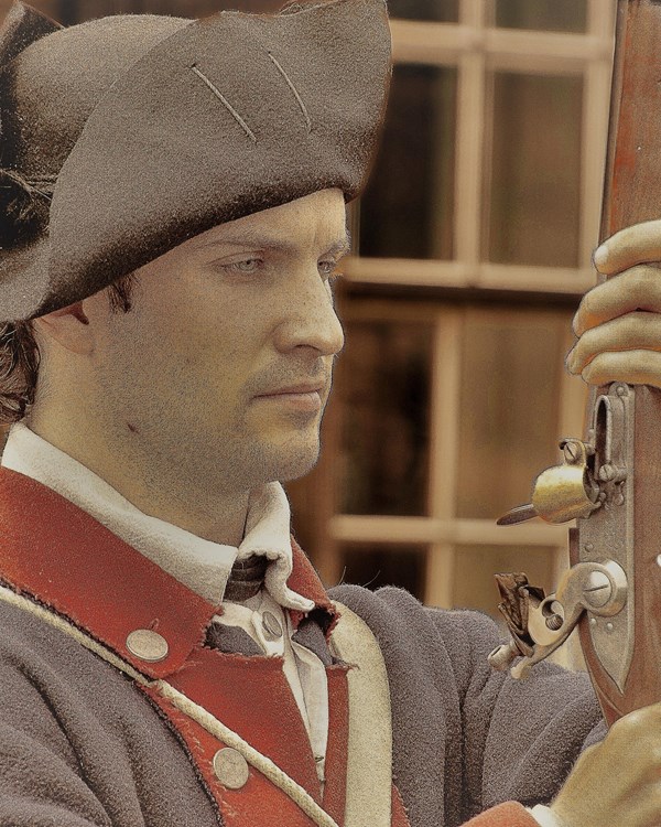An image of a younger man holding his musket in front of his face.
