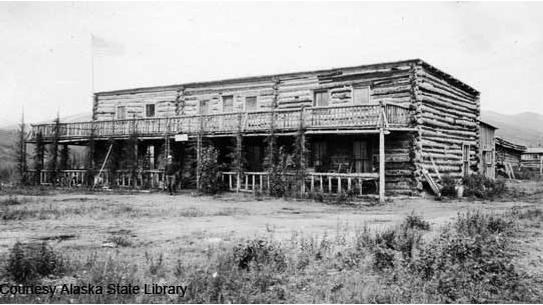 a two story roughly constructed log building