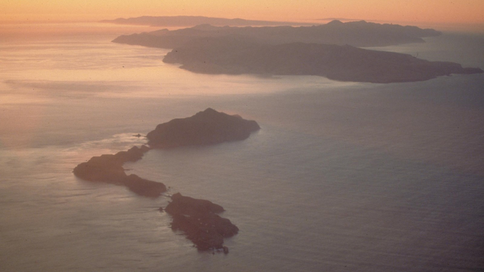 Aerial view of chain of islands at sunset.