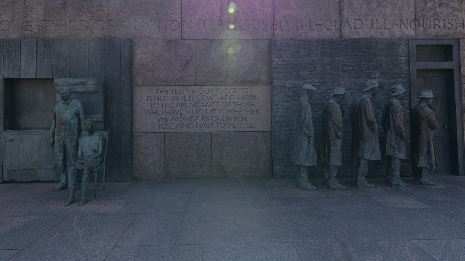 Depicted to the left is a statue of a couple. Depicted to the right is a line of statues.