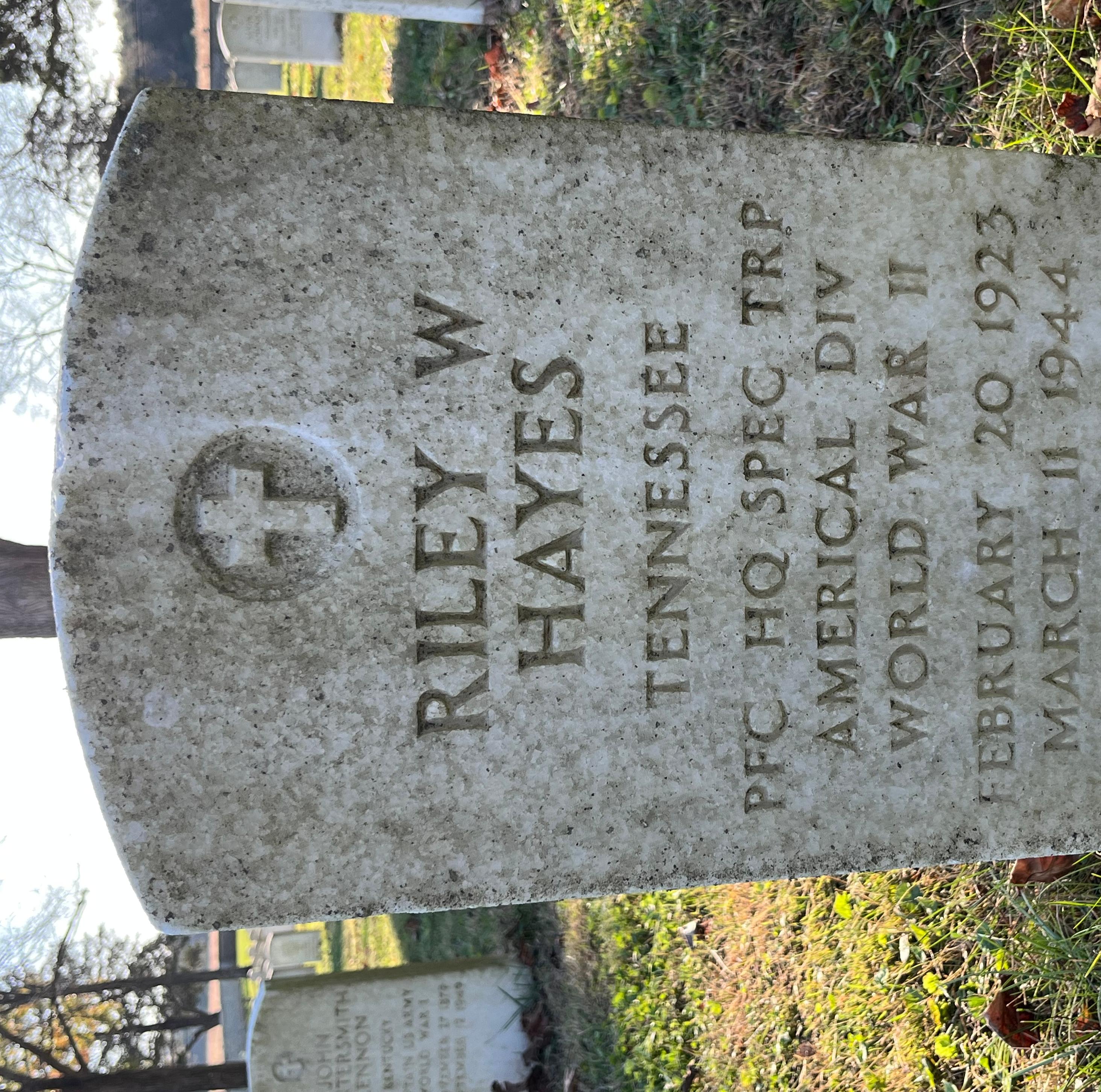 Headstone reading "Riley W Hayes Tennessee PFC HQ SPEC TRP Americal Div WWII Feb 20 1923 Mar 11 1944