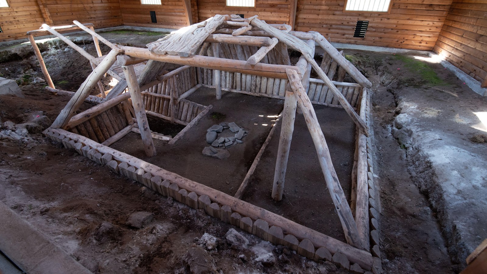 The scaffolding of a building with a fire pit in the center