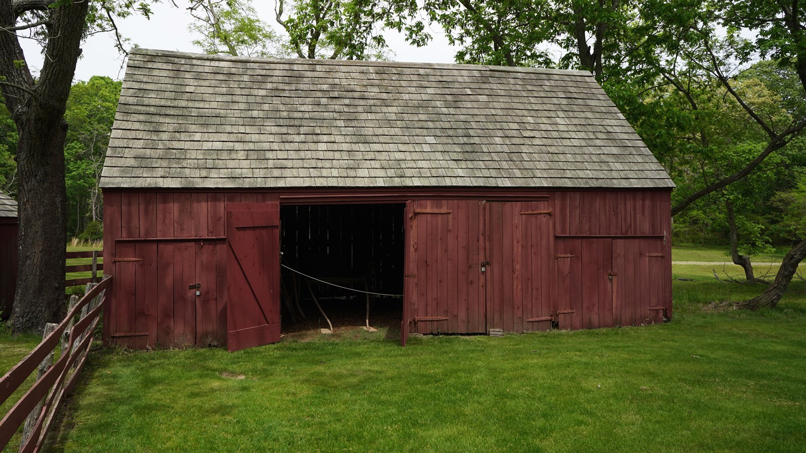 A large red barn with wide doors for housing carriages. 