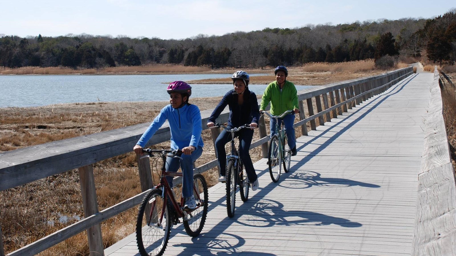 Visitors ride along a bridge over Nauset Marsh on the Nauset Bike Trail.