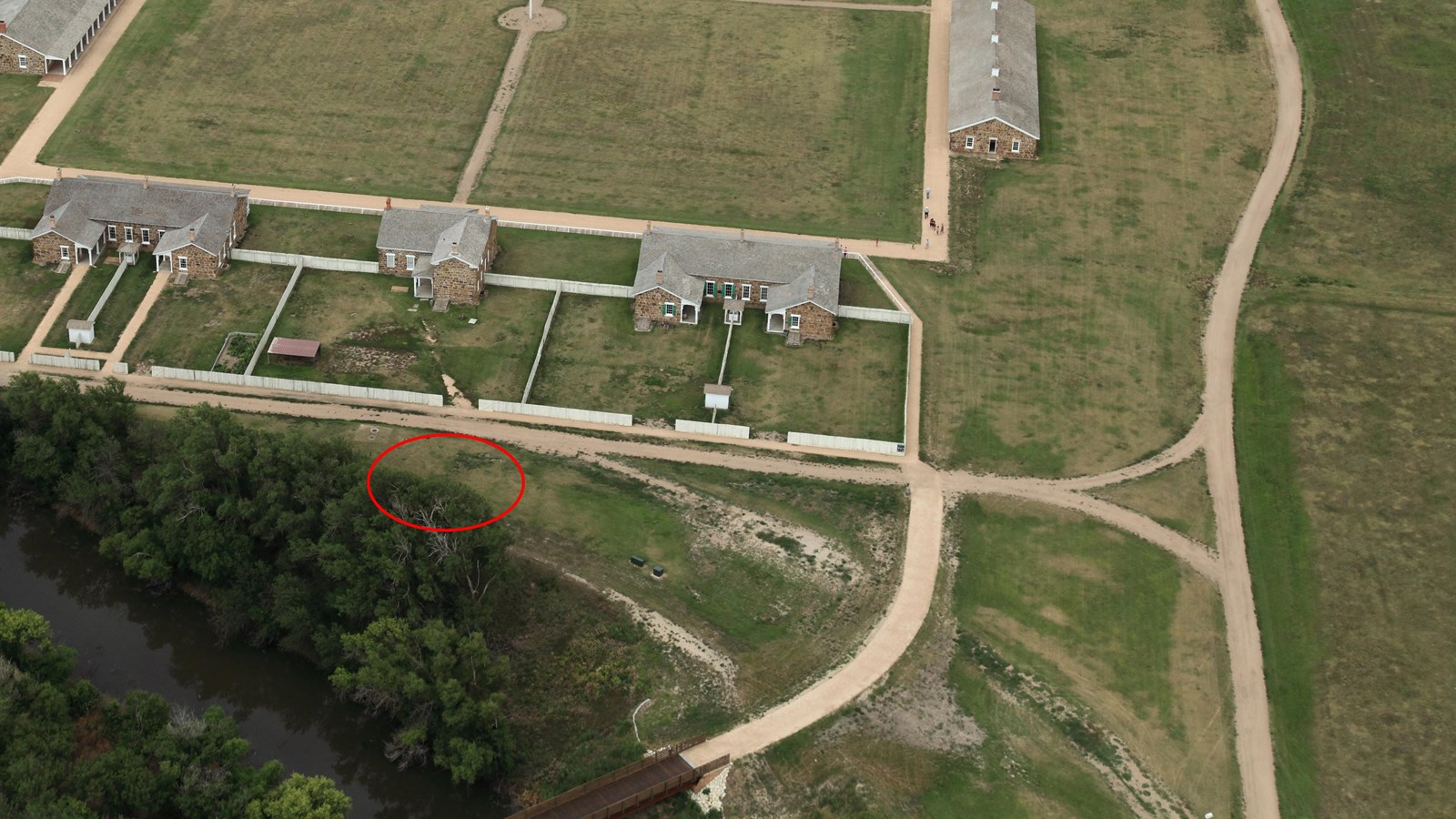 Aerial view of Pawnee River bank behind Officers\' Row with Ice House location marked by red cirlce.
