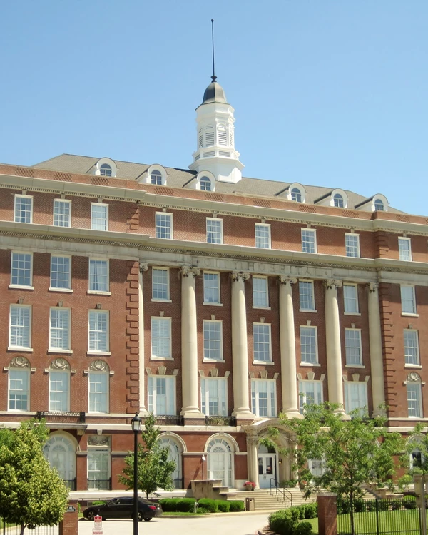 Large, five-story, red brick building with a copula on top