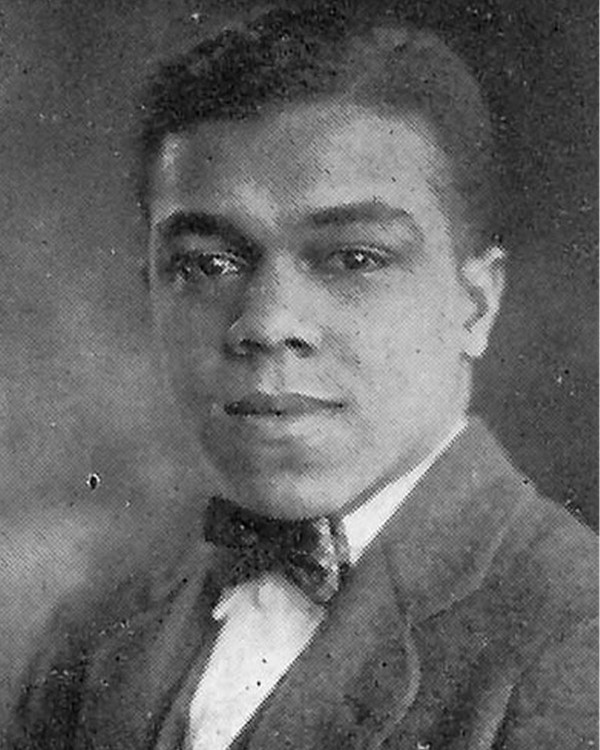 Black and white photo of a man in a suit and bowtie.