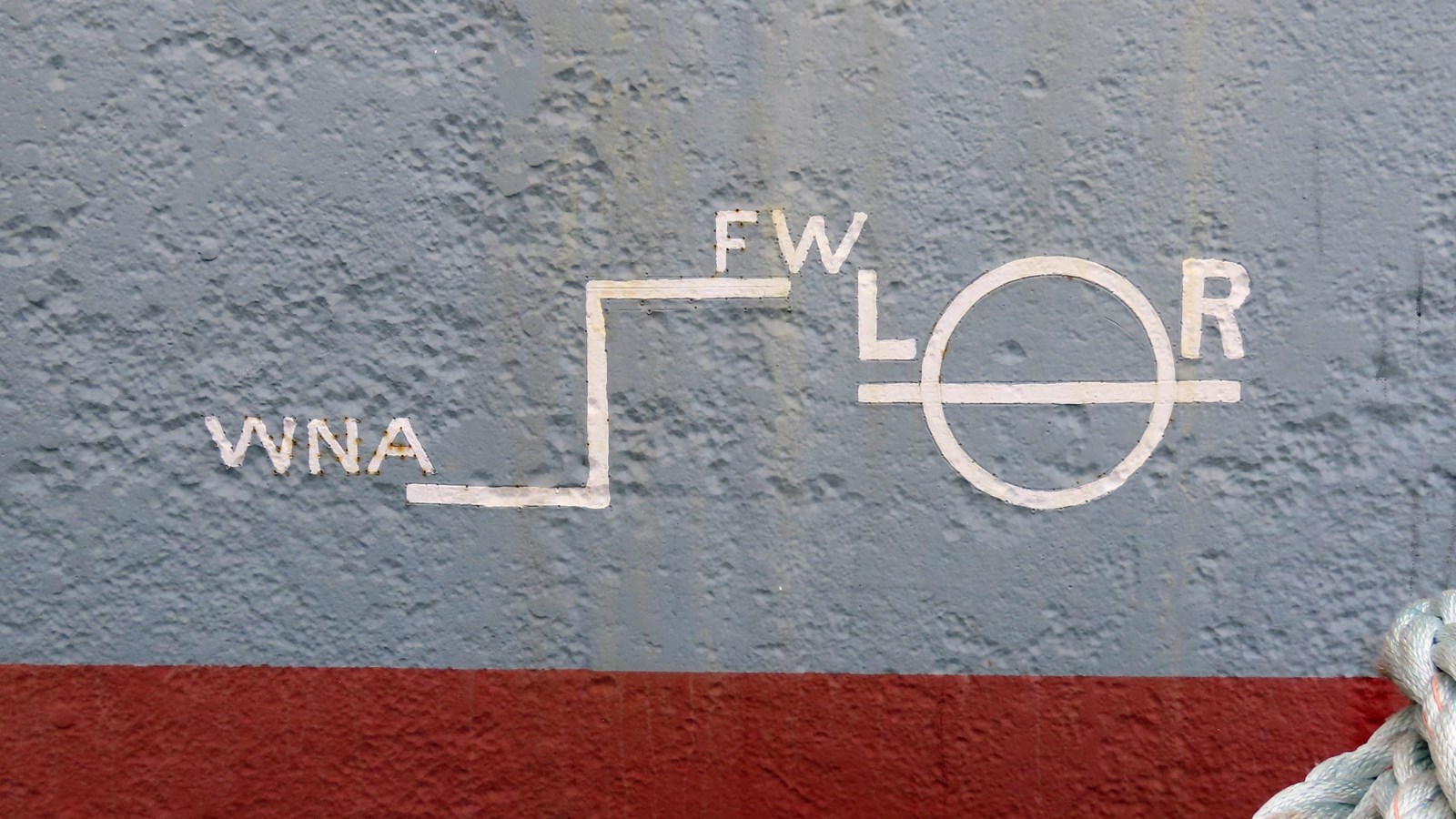 White markings and lettering painted on the side of Balclutha\'s gray hull