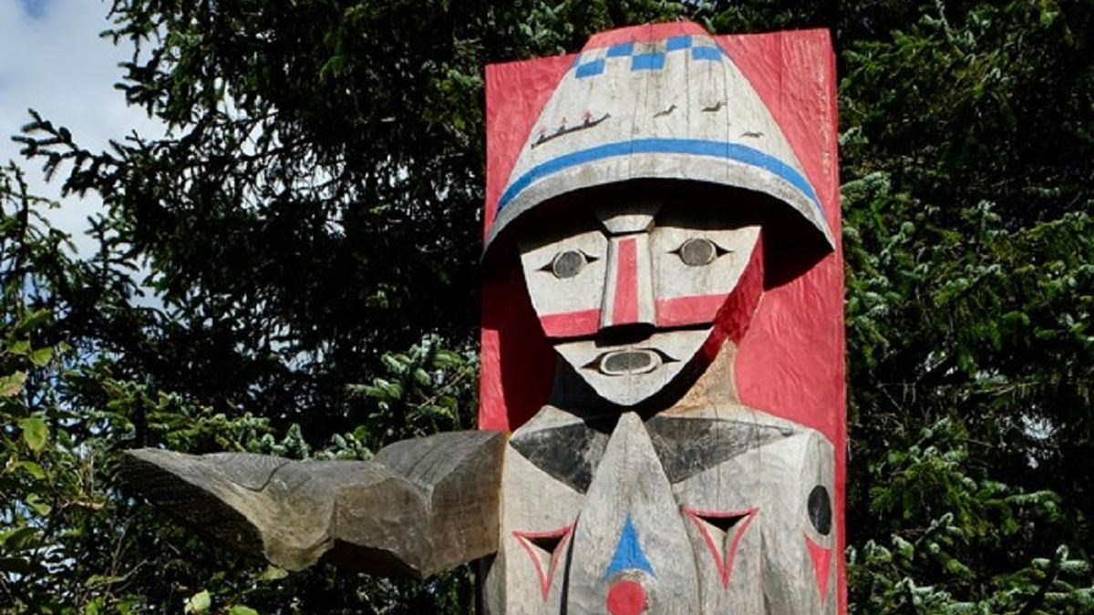 A Chinookan-style carved cedar statue of a young native man painted with geometric designs