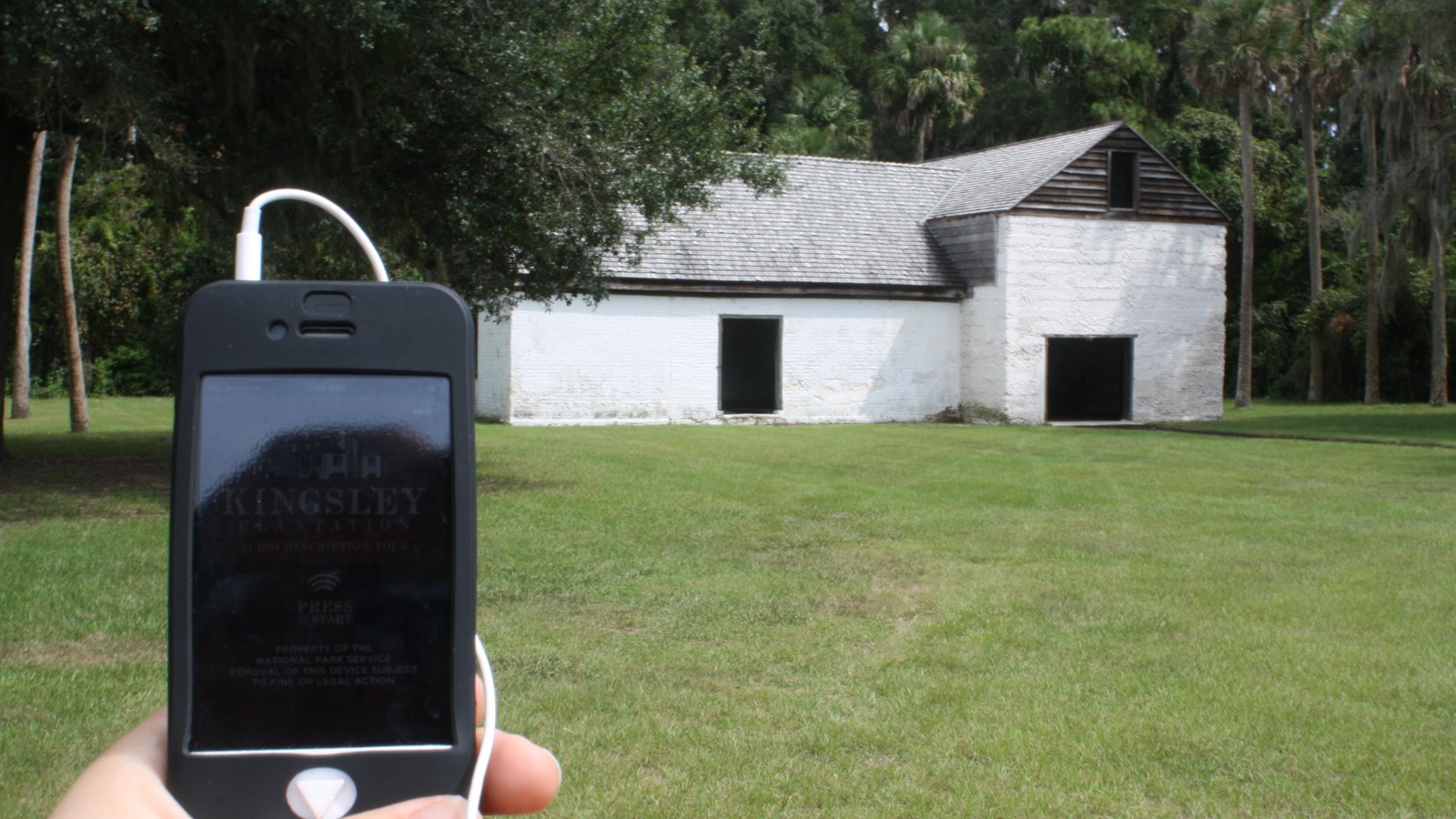 an audio tour device outside of a two story tabby barn