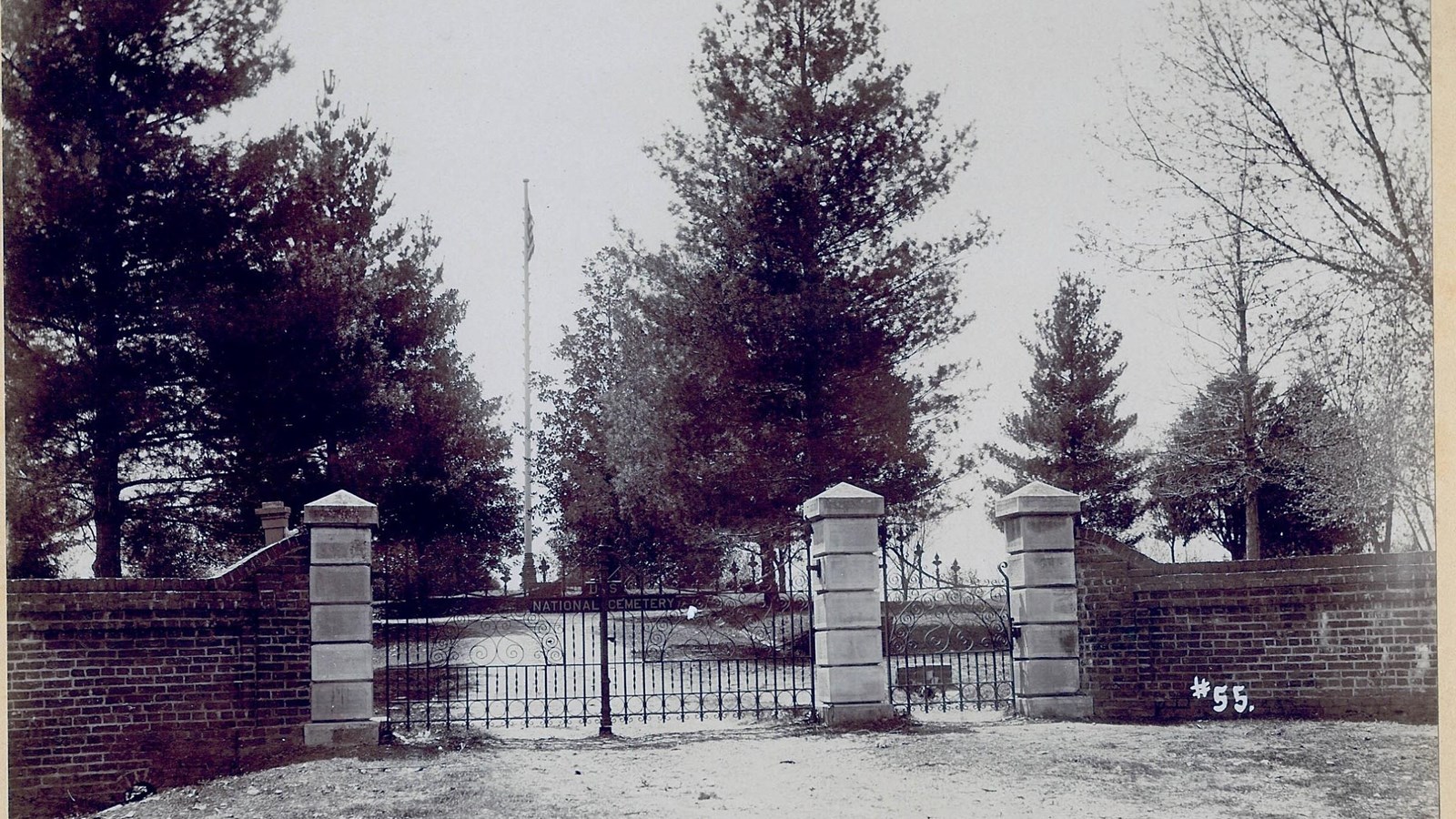 Black and white image of the cemetery gates.