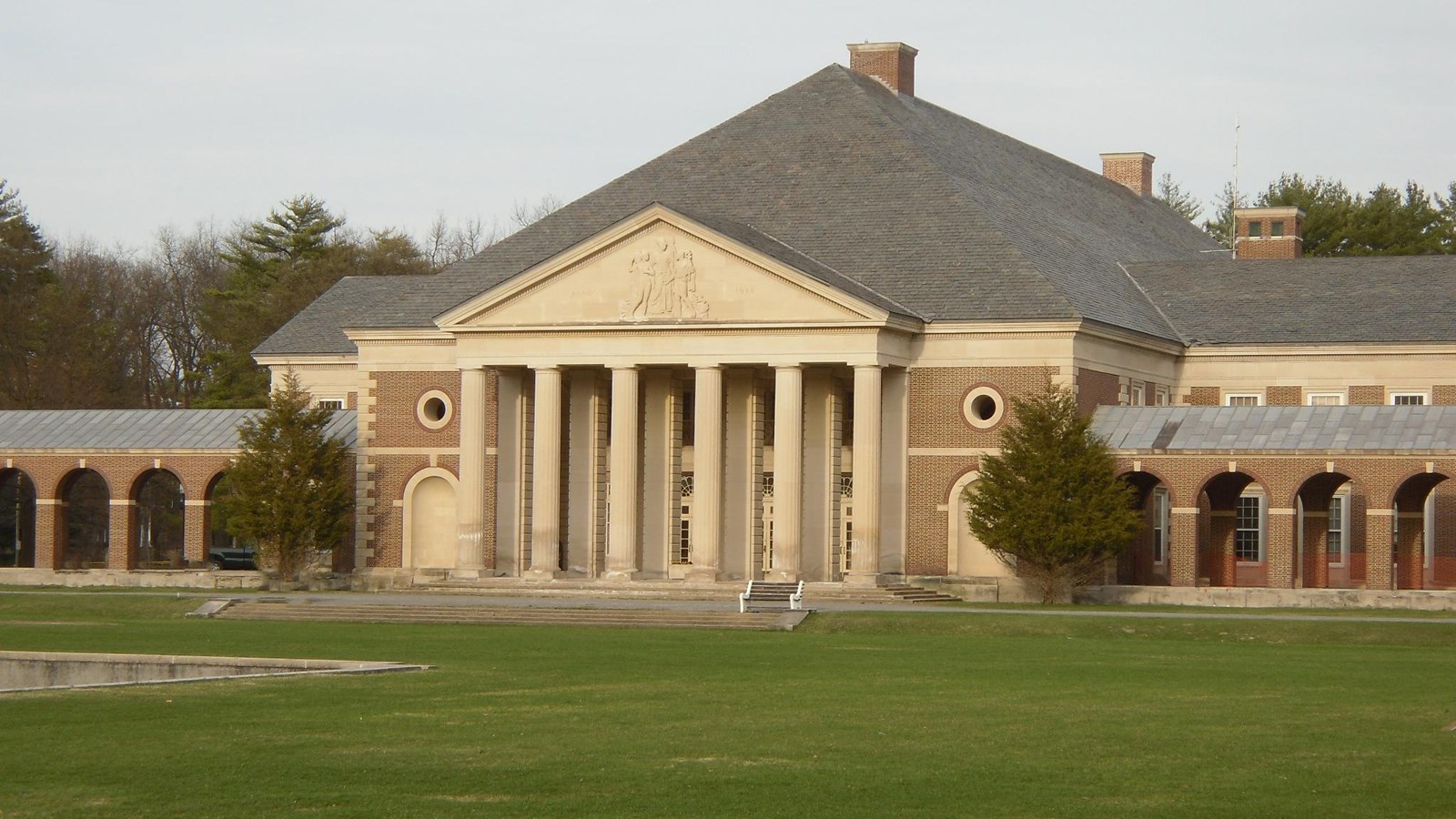 large stately building with a portico in front and wings to the side