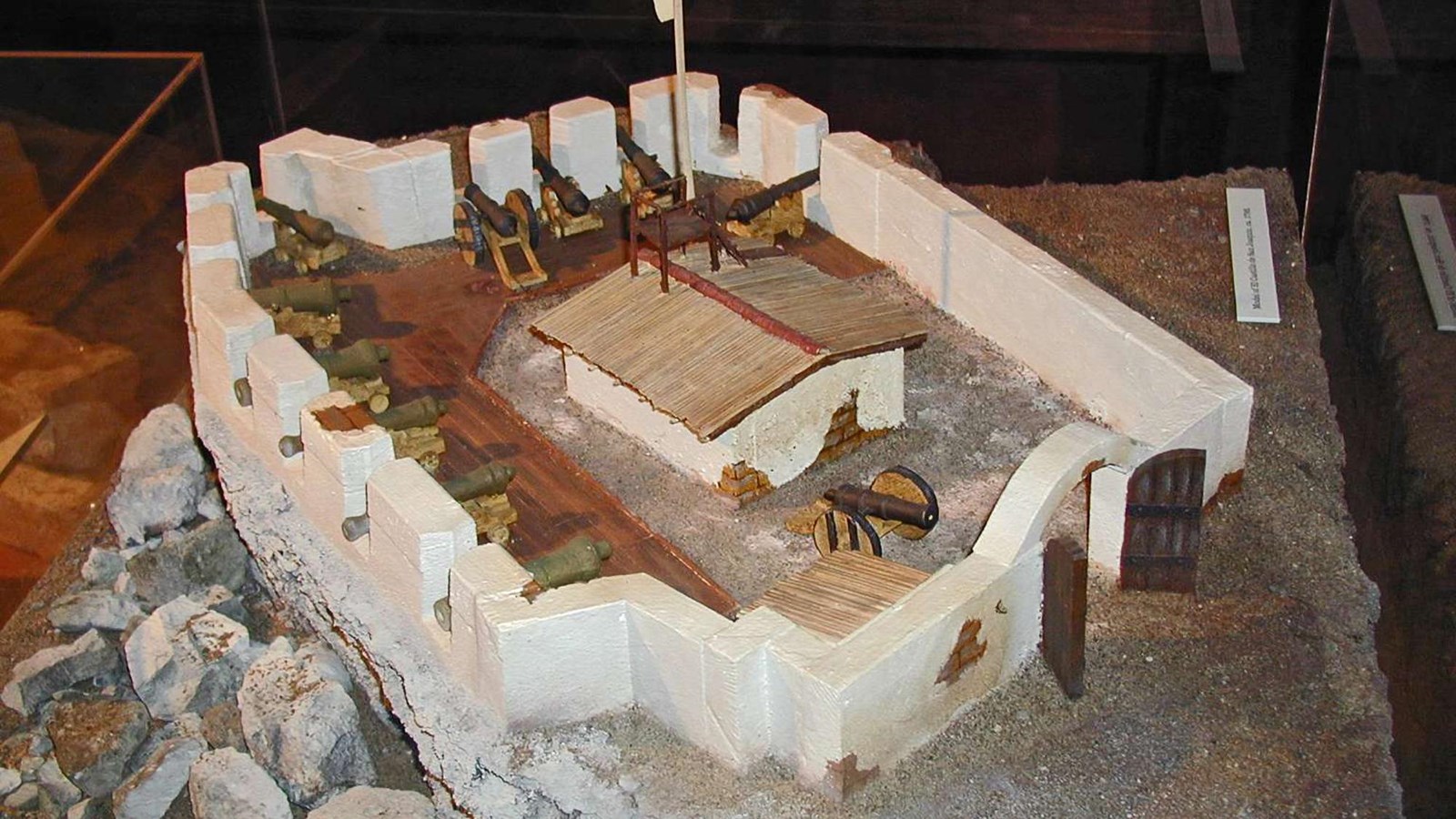 A diorama of Spanish Castillo de San Joaquín fort with thick, white adobe walls, bronze cannons.