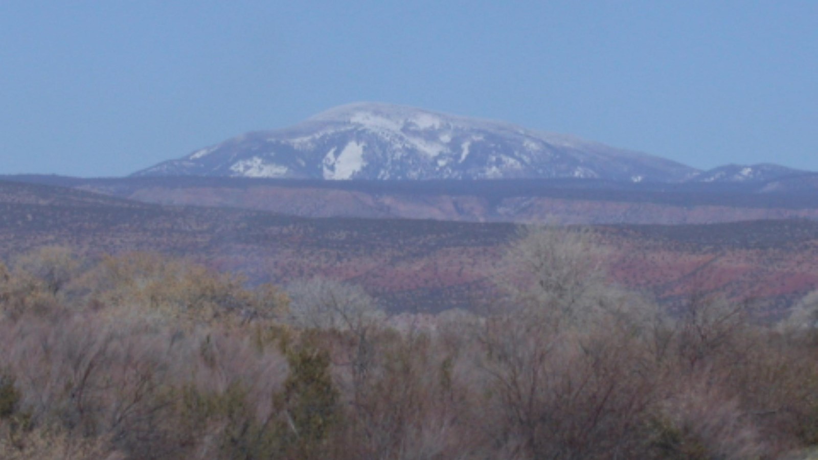A distant mountain with patchy snow