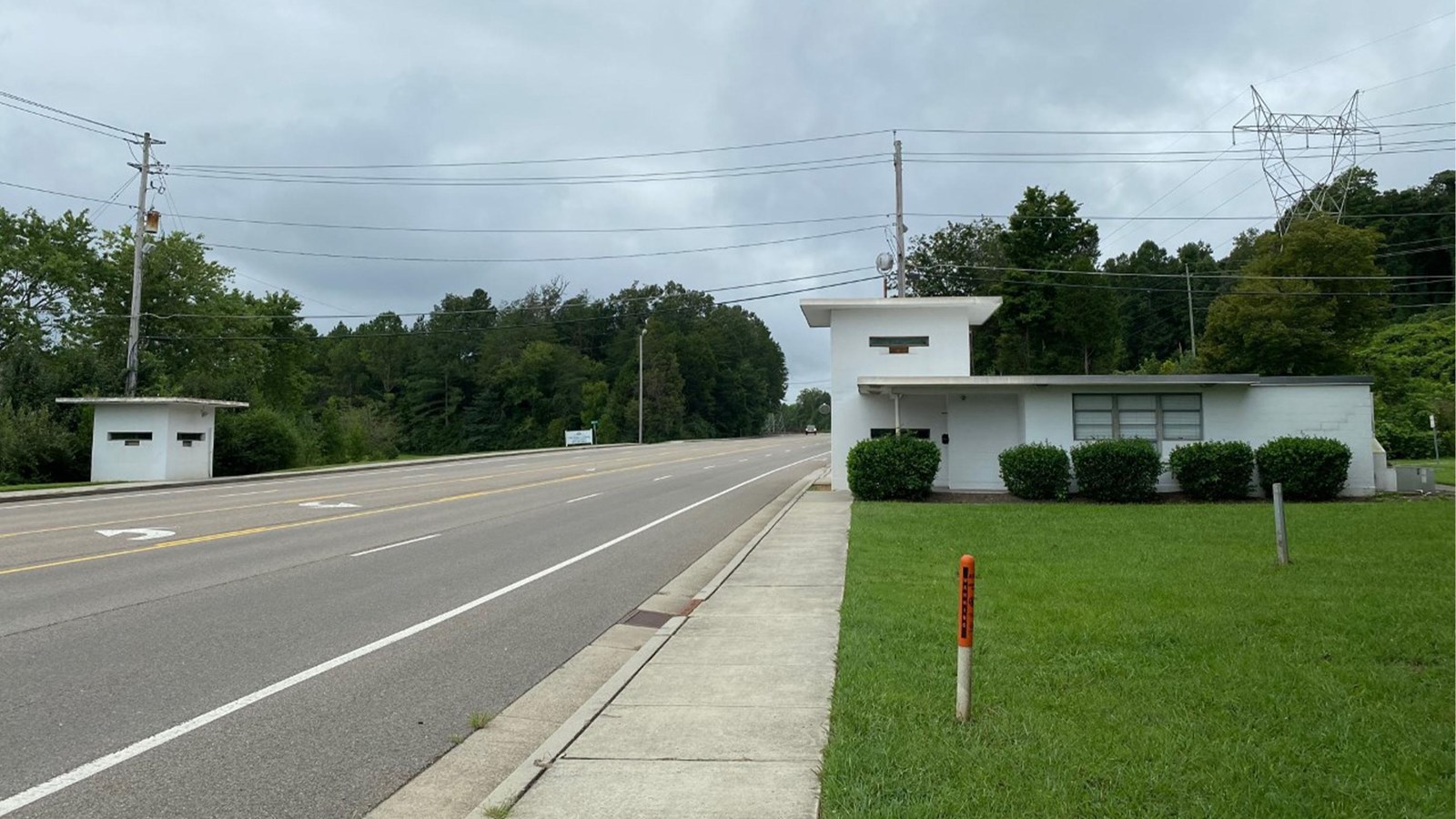 A small white building at left and larger white building at right, split by highway