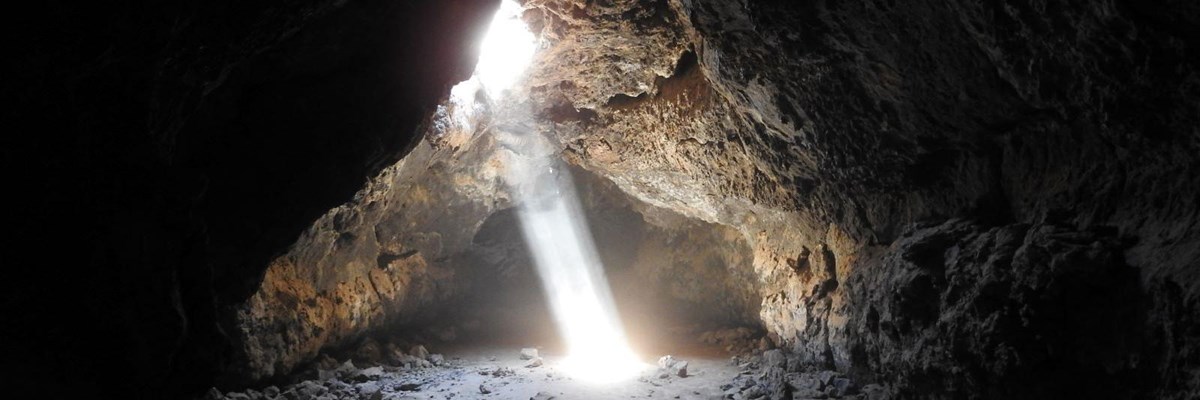 A beam of light shines into the lava tube