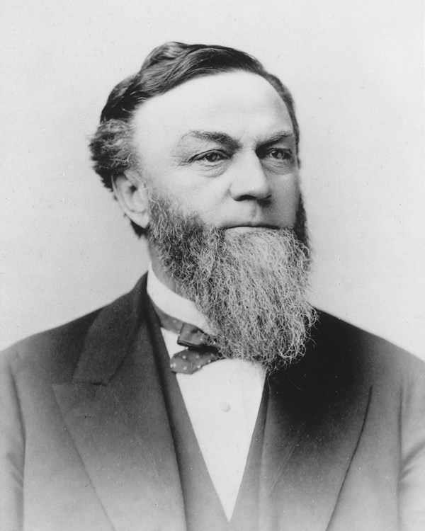 historic black and white photo of a 62 year old man with a long beard in a suit