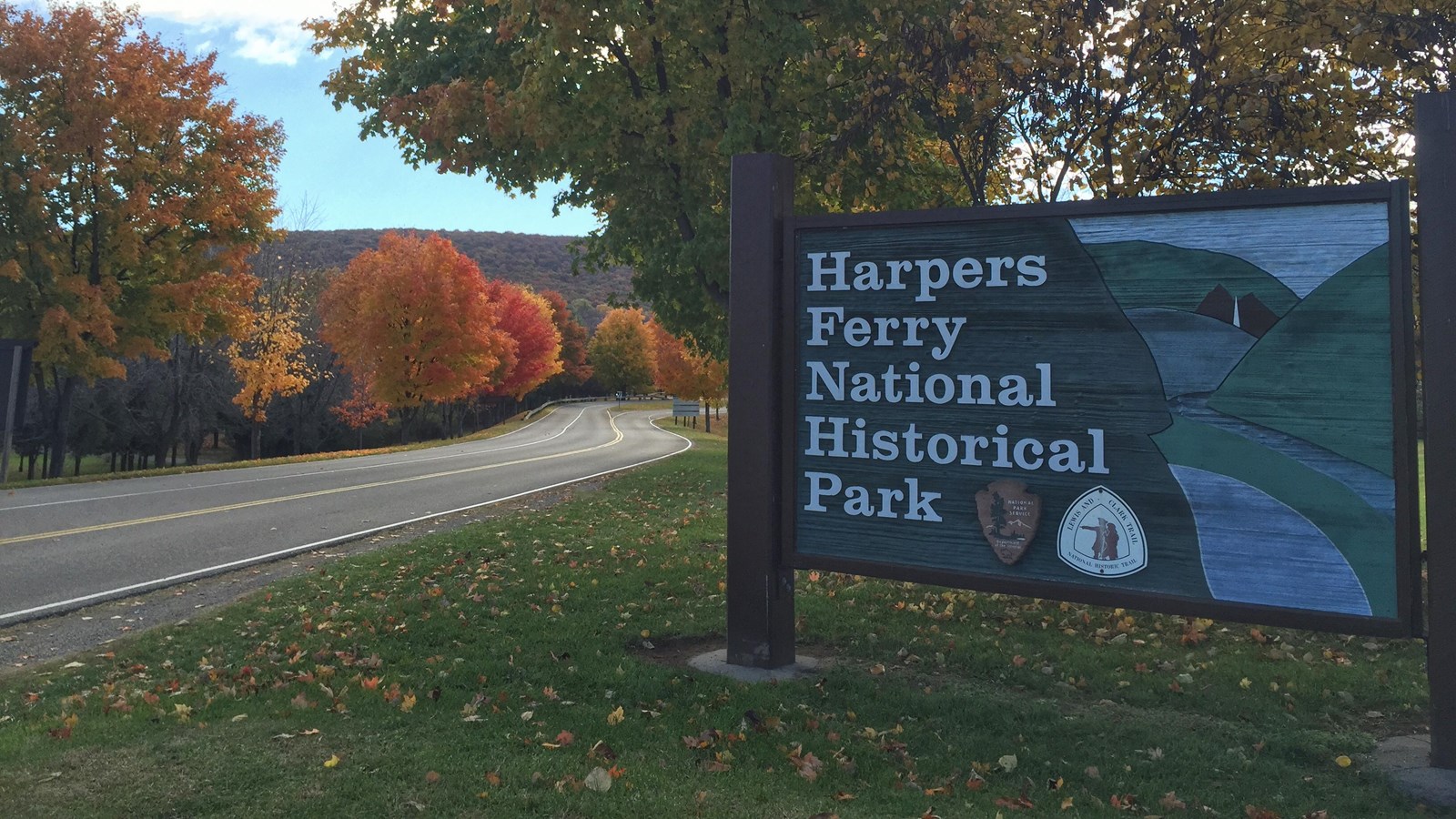 entrance sign beside road reads Harpers Ferry National Historical Park