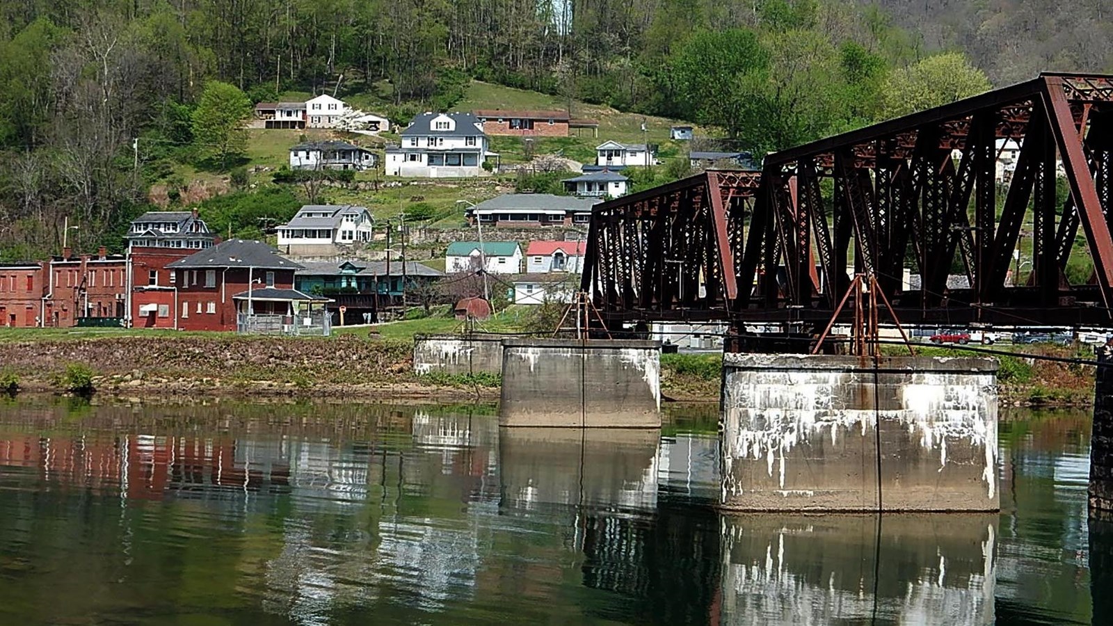 a bridge crosses a river leading into a small town