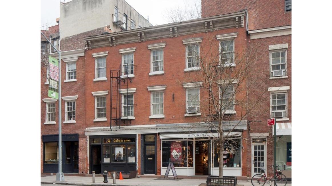 Three story apartment building with a storefronts on the ground floor