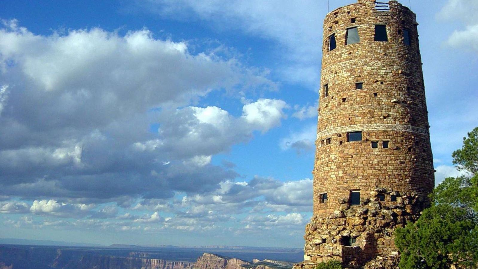 A circular stone tower, 70 feet tall perched on the edge of a vast canyon