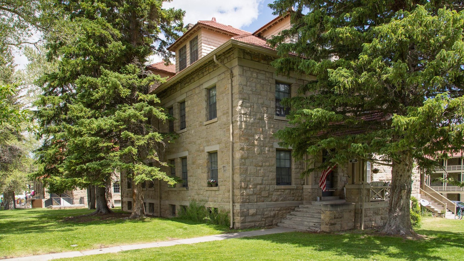 The corner of a historic, stone building with a red roof.