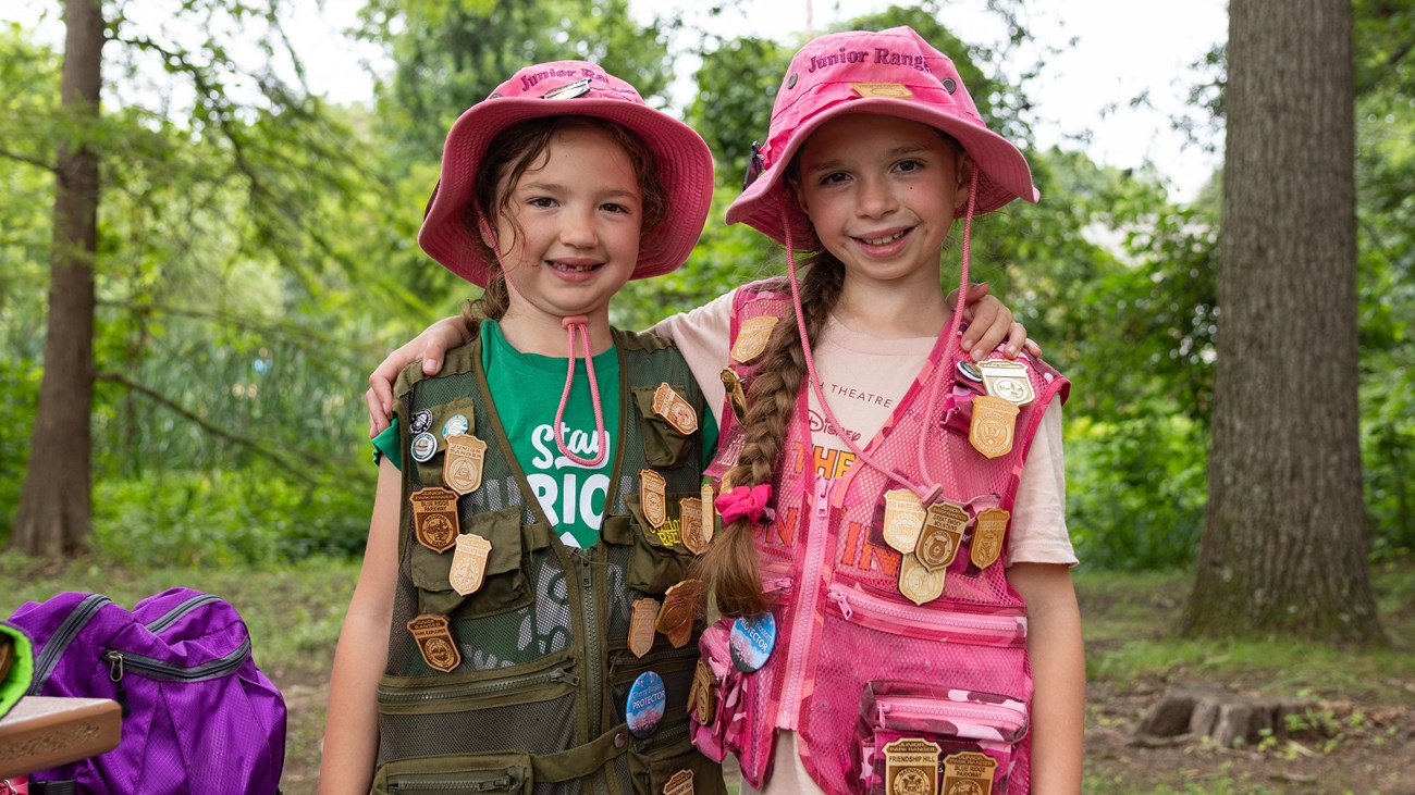 Two Junior Rangers display their Junior Ranger badge collections at Kenilworth Aquatic Gardens