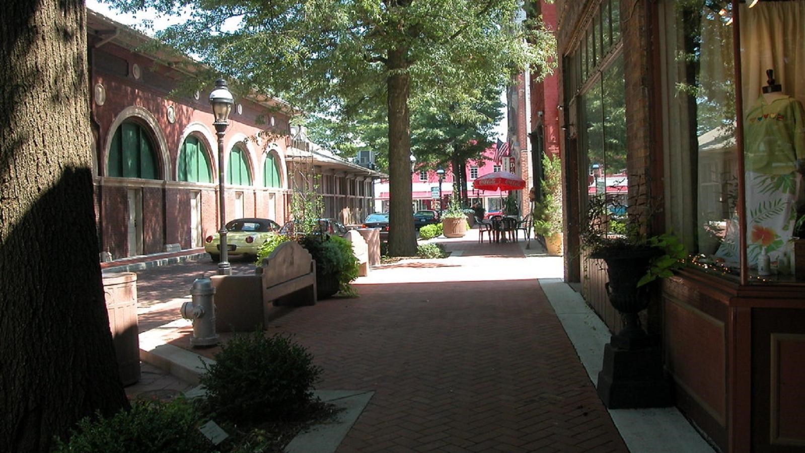 A landscaped cobblestone sidewalk in front of historic shopfronts 