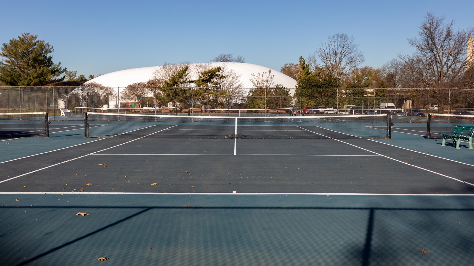 A fenced outdoor tennis court.