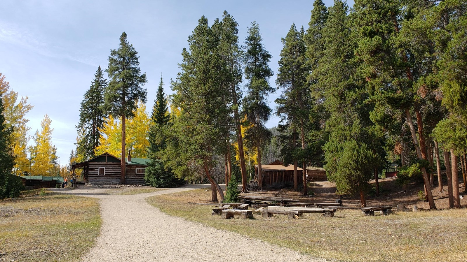 A group of park visitors are standing in front of a historic cabin in the Holzwarth Historic Site