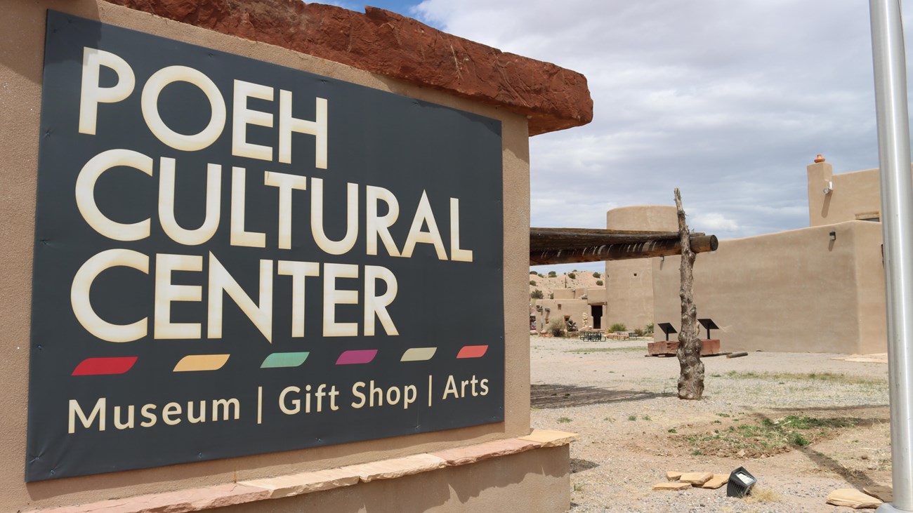 A large sign with white text on a black background, “POEH CULTURAL CENTER Museum | Gift Shop | Arts”
