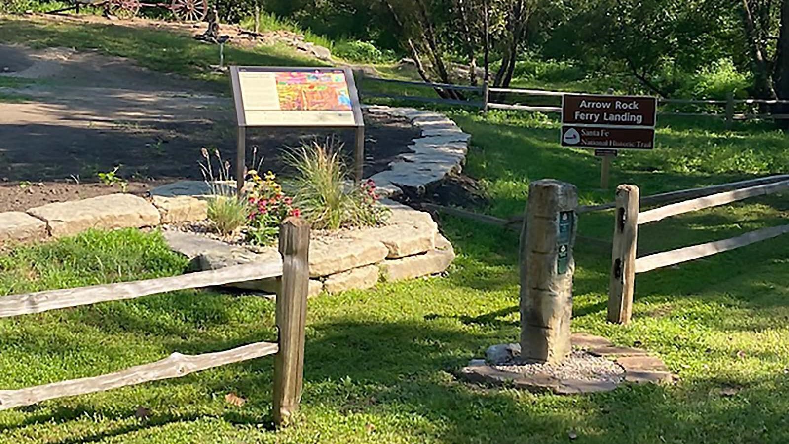 Grassy field with the remnants of a covered wagon and remnants of wooden ferry landing posts