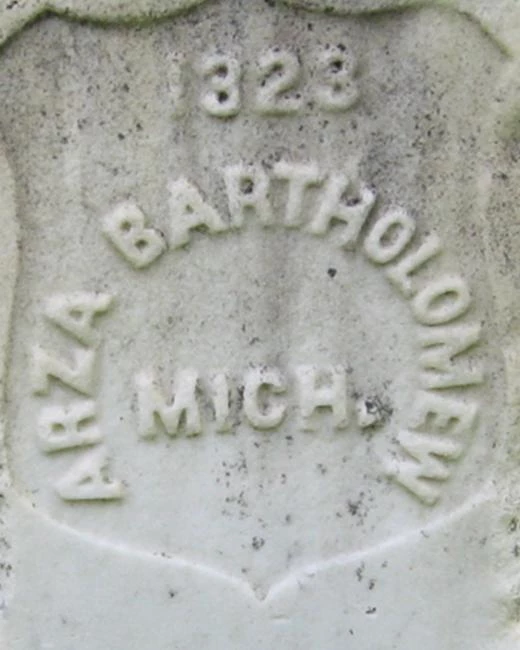 A white marble headstone for Arza Bartolomew.